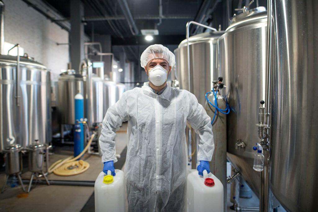 industrial worker holding plastic cans with chemicals production plant, Affordable Storage